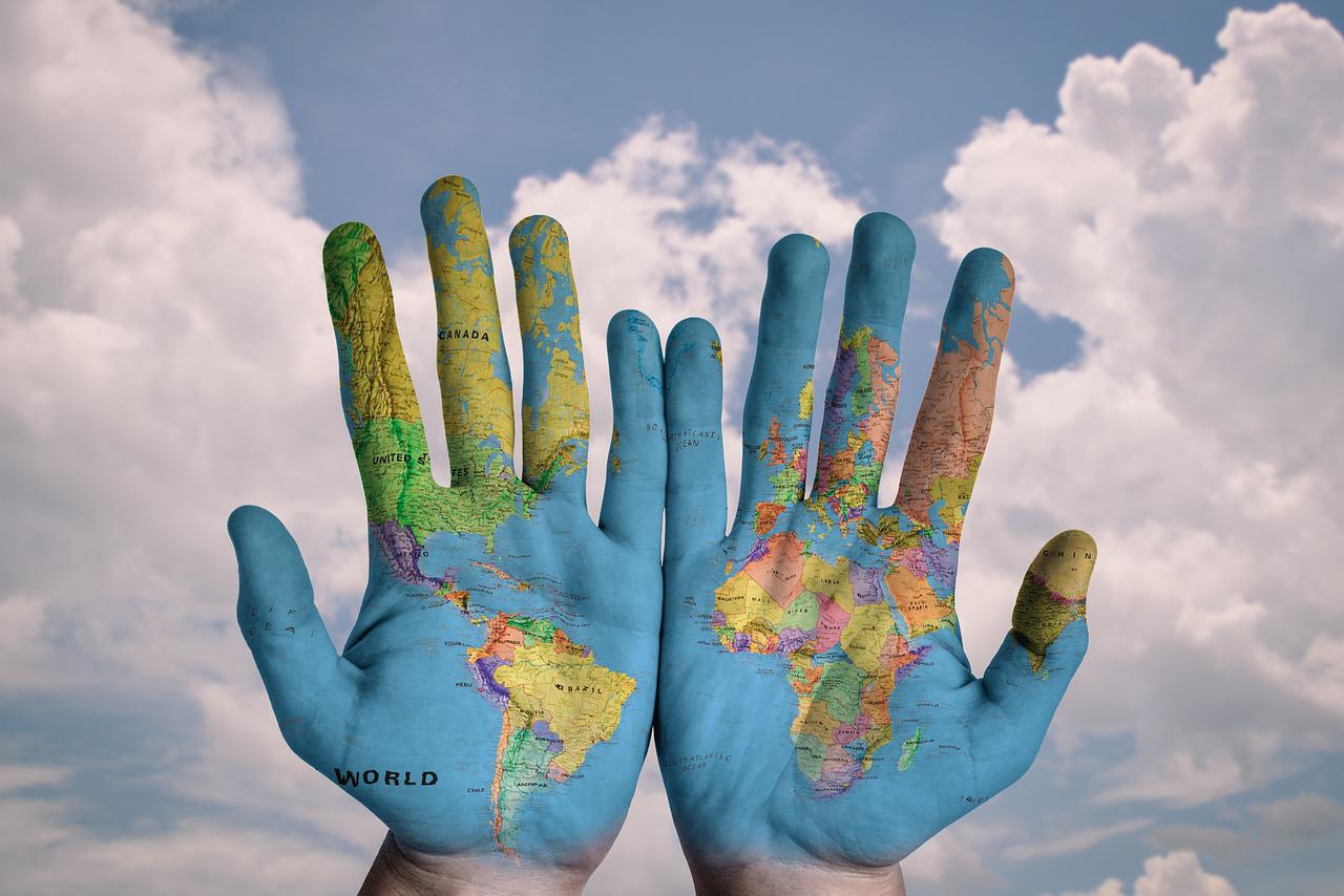 stock image of two hands painted with world map - Earth Day 2022