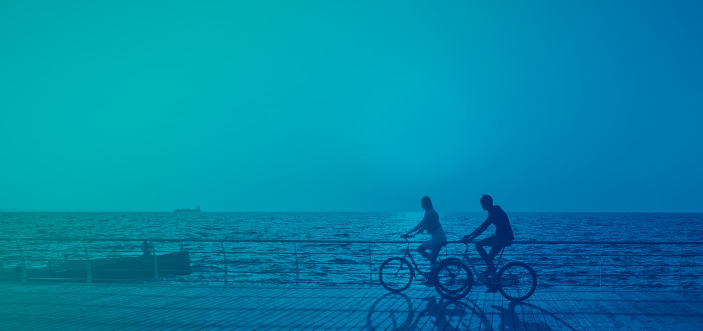 Image of two cyclists against a sunset