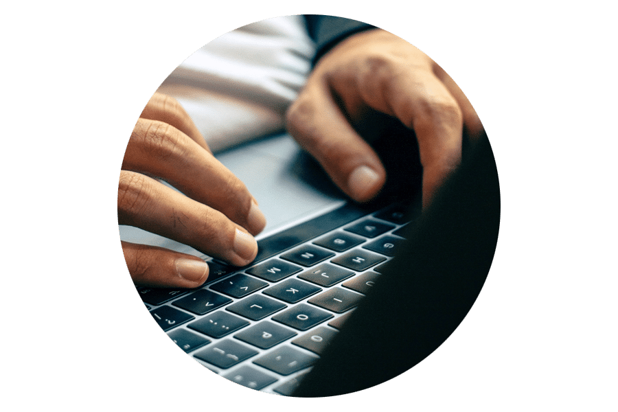 Roundel closeup image of two hands typing on a laptop keyboard for blog